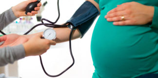 Pregnant woman at doctor's office having pressure measured