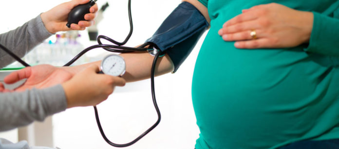 Pregnant woman at doctor's office having pressure measured