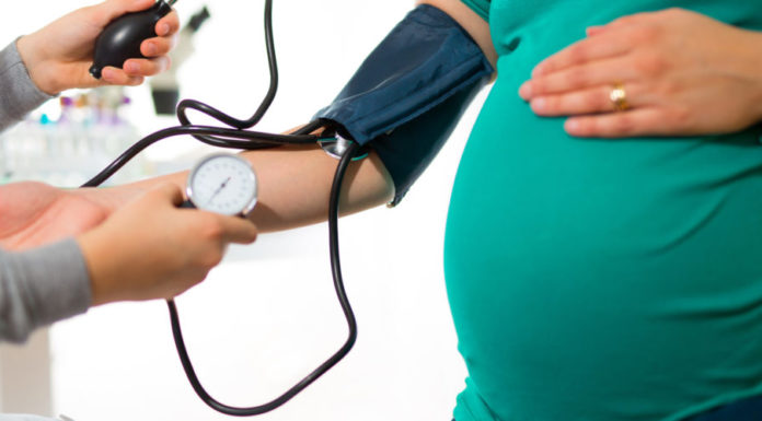 Pregnant woman at doctor's office having pressure measured